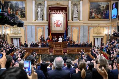 Le pape Léon XIV, vêtu de blanc, lève la main droite pour saluer lors de son discours au Parlement espagnol.