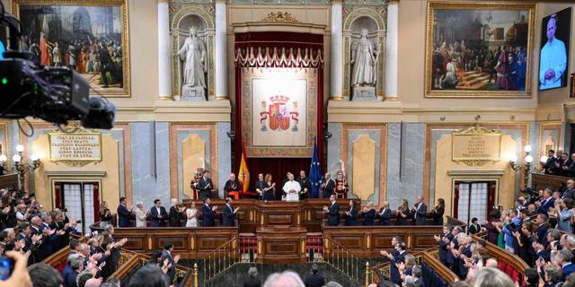 Le pape Léon XIV, vêtu de blanc, lève la main droite pour saluer lors de son discours au Parlement espagnol.